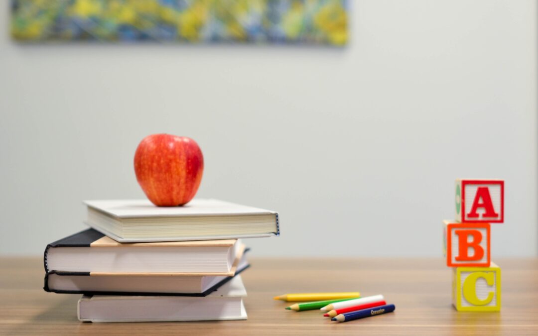 Libros, lápices para colorear, letras de abecedario en cubos que muestran la importancia de un seguro educativo de Futuro Seguro